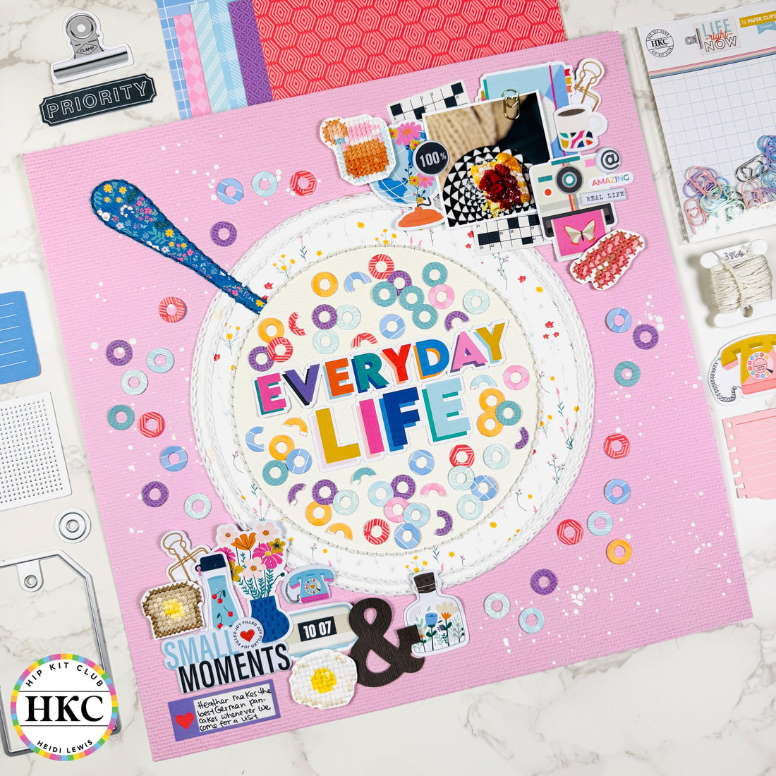 Heidi Lewis scrapbook layout featuring a paper pieced cereal bowl with hand embroidery patches, die cut Froot Loops, and white paint splatters using February 2026 Hip Kits